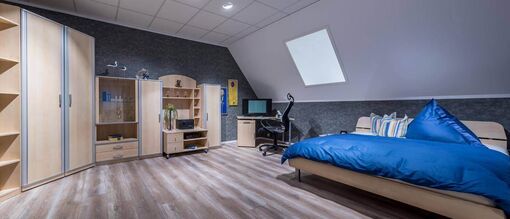 Schlafzimmer mit Kingsize-Holzbett und Schrankwand mit Holzfront