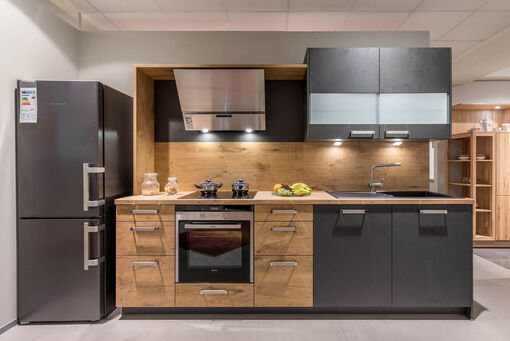 Küchenzeile mit Holzfronten sowie grauen Türen und Oberschränken