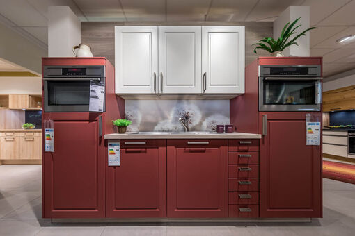 Küchenzeile mit roten Fronten und weißen Oberschränken
