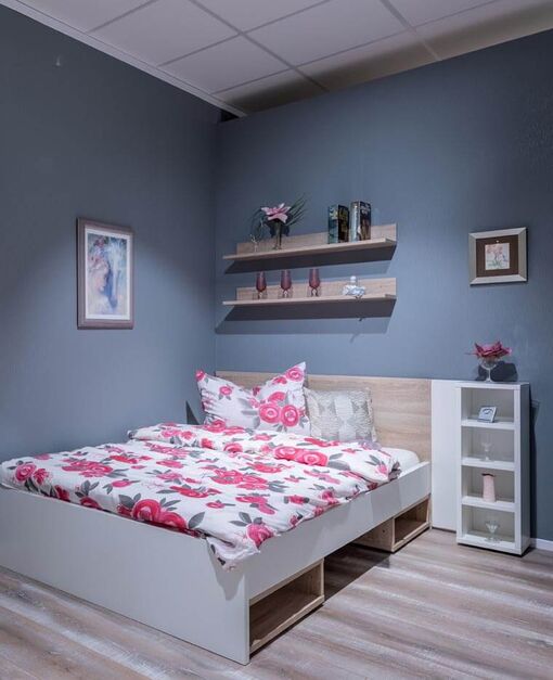 Kleines Schlafzimmer mit weißem Bett mit Stauraum